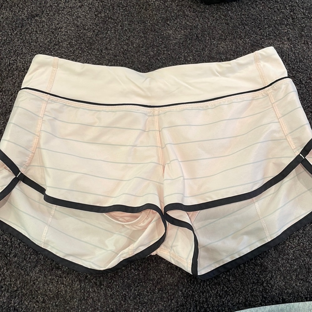 LuluLemon light pink shorts, with grey stripes and black trim.